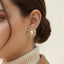 Close up of woman wearing vintage style oval pearl and crystal stud earrings royal aesthetic.