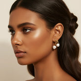 Close-up of a model with glowing, medium-dark skin wearing The Chérie Pearl Earrings, showing the beautiful contrast of the white pearls against her complexion.