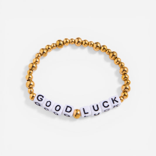 Gold beaded bracelet with white letter beads spelling GOOD LUCK motivational jewelry.