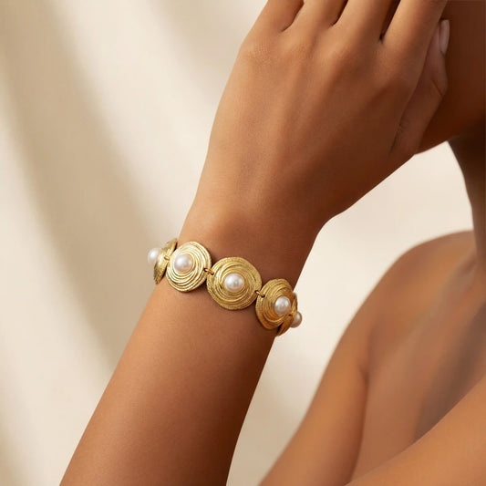Detailed shot of The Hera Bracelet on a model's arm, demonstrating how the gold medallions articulate and wrap comfortably around the wrist.
