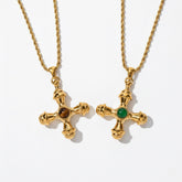 A detailed studio shot of The Jupiter Necklace by Luminova, showcasing both the Tiger Eye and Green Agate gemstone options in the vintage-style gold cross pendant.