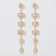 Pair of long gold linear earrings with rectangular and teardrop cubic zirconia stones.