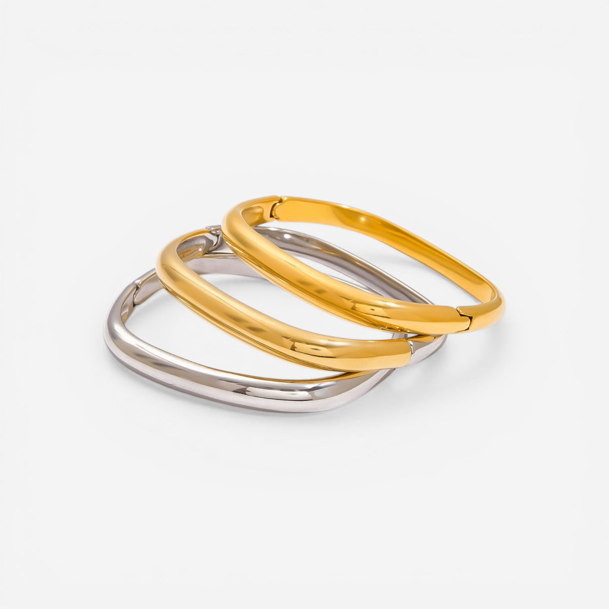 Stack of three minimalist square hinge bangles in gold and silver waterproof jewelry.