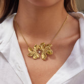 A close-up of a model wearing The Persephone Necklace against a classic white shirt, highlighting its bold, artistic presence on the collarbone.