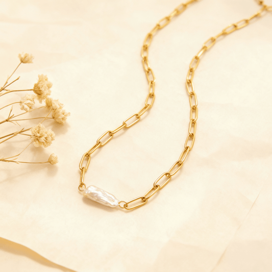 The Aphrodite baroque pearl necklace gently coiled, with the one-of-a-kind pearl at the center, styled with delicate dried flowers to emphasize its natural beauty.