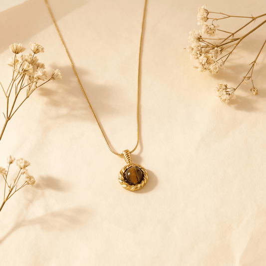 A close-up macro shot of the Tiger's Eye pendant, detailing the natural, shimmering bands of golden-brown and dark brown within the stone.