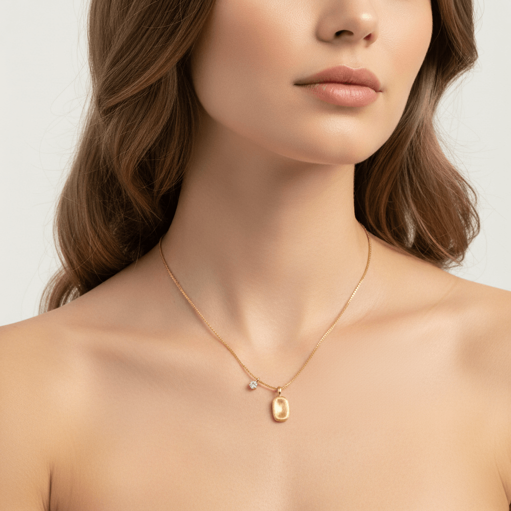 A close-up on a model's neck right after a shower, with small water droplets on her skin and on The Signature Necklace. The necklace remains pristine and lustrous, visually proving its waterproof and tarnish-free qualities.