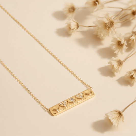 Heartline Bar Necklace — gold bar pendant with heart-shape detailing and stones, romantic and sleek.