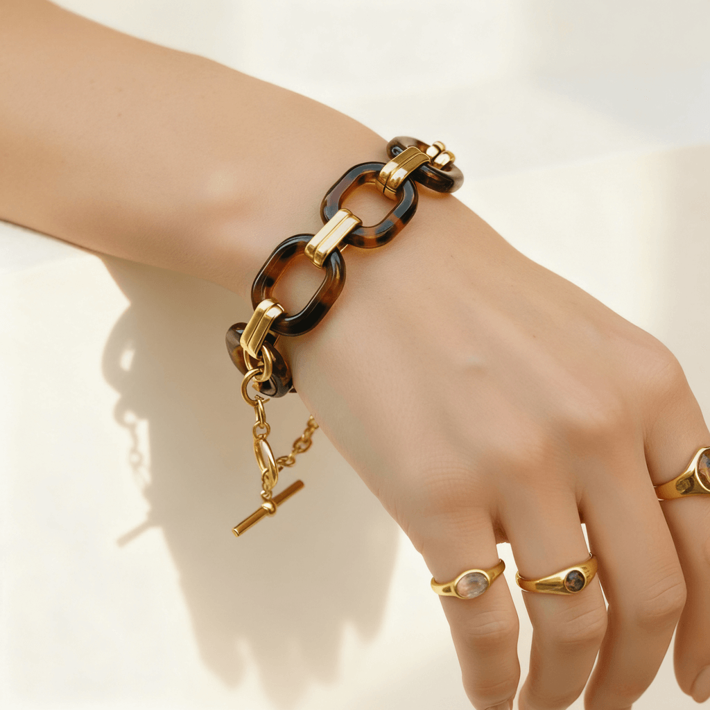 Model's hand showcasing the Florence tortoiseshell bracelet, paired with delicate gold rings to illustrate its versatile styling potential.