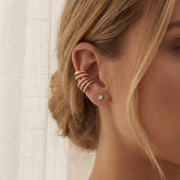 Close up of blonde woman wearing stacked gold crystal ear cuffs no piercing needed.