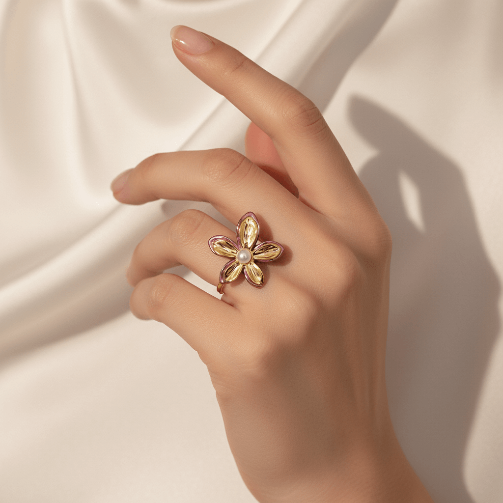 A model wearing a simple, white sleeveless top, with her hand placed on her shoulder to showcase The Orchid Ring. The ring acts as the sole pop of color and artistic detail, making a powerful statement against the minimalist backdrop.