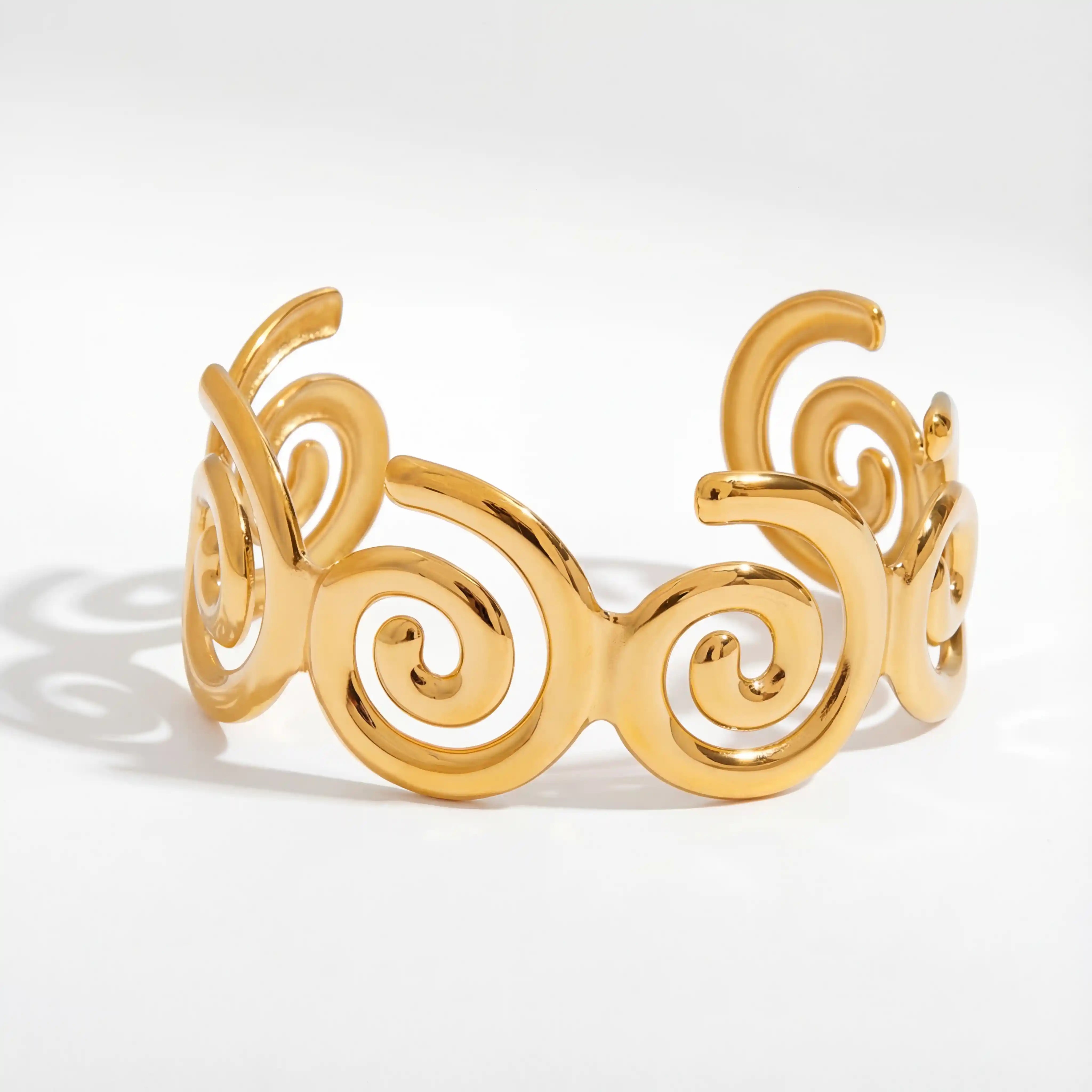 Abstract spiral wave cuff bracelet gold stainless steel cutout design.