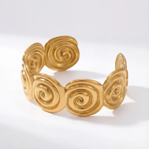 Side view of adjustable wide gold cuff with cutout wave pattern.