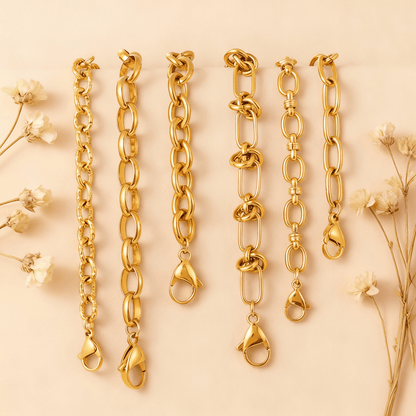 The Amalfi Layering Set by Luminova: all six waterproof gold chain bracelets laid out vertically, showcasing each unique style on a soft beige background with dried flowers.