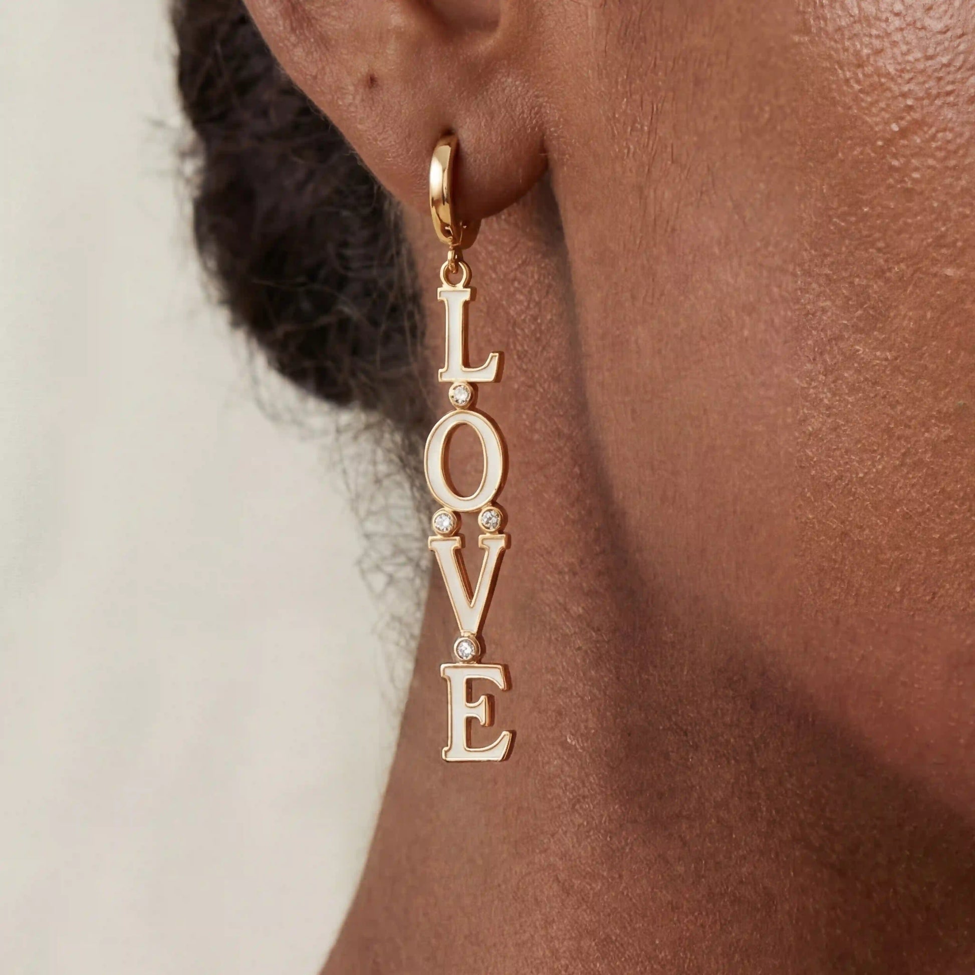 Close up of woman with dark skin wearing gold Pythia cuff bracelet with sculptural fluid design.