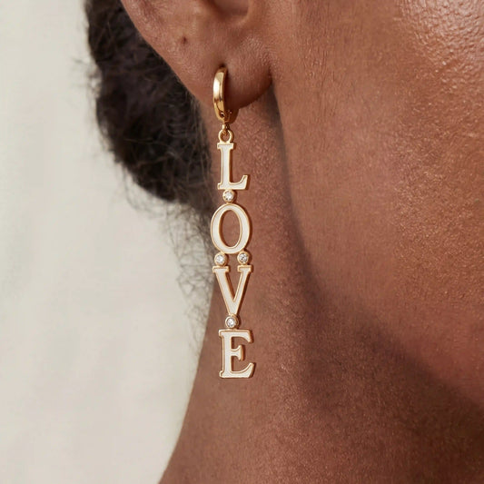Close up of woman with dark skin wearing gold Pythia cuff bracelet with sculptural fluid design.