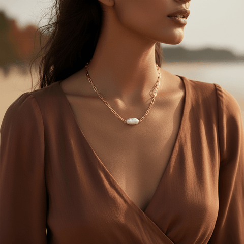 Model wearing The Aphrodite pearl necklace outdoors with a casual brown top, illustrating its durable, waterproof quality for everyday adventures.