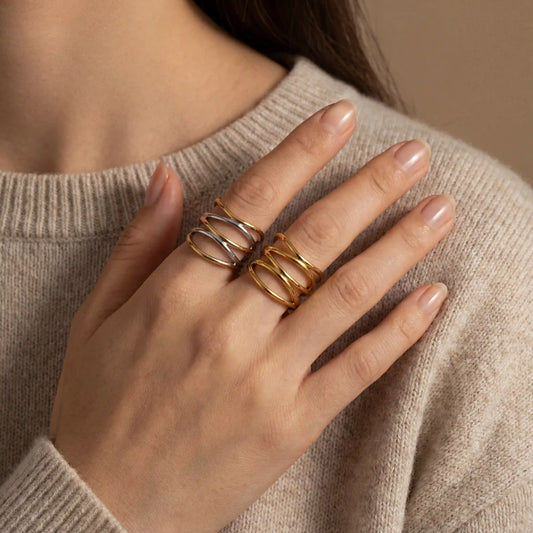 Close up of woman wearing mixed metal and gold Ariadne rings with beige sweater.