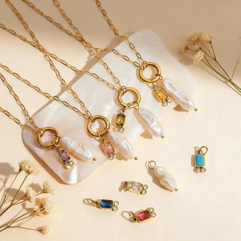 An artistic close-up of the personalized birthstone and baroque pearl charms from The Astoria Necklace collection, highlighting the different vibrant gem colors.