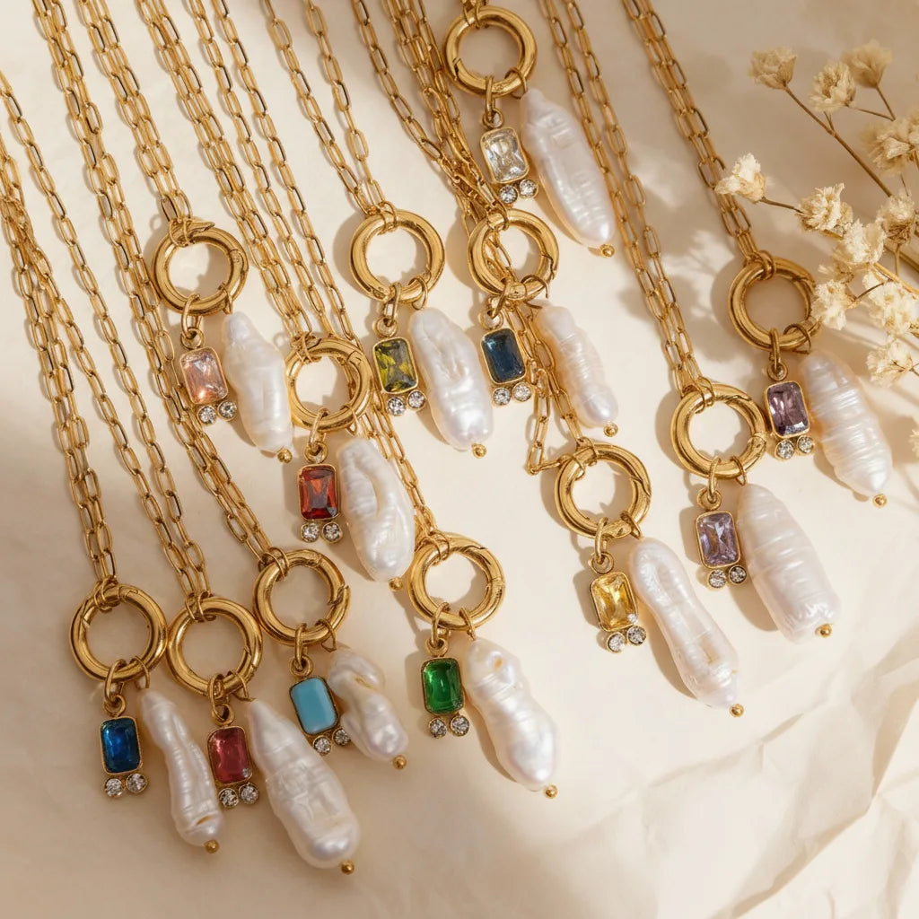 Several Astoria Necklaces layered together on a luxurious silk cloth, showing the beautiful interplay of the colorful birthstones and lustrous pearls.