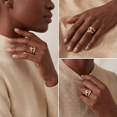 Model with dark skin styling gold crossover ring with baguette stones everyday jewelry.