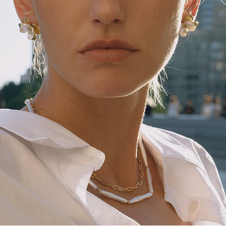 An elegant side profile of a model wearing The Callisto Necklace, showing how the double strands gracefully follow the curve of the collarbone