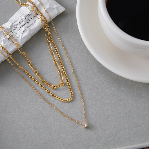 The Charites layered necklace displayed next to a cup of coffee, embodying effortless, everyday chic and sophistication.