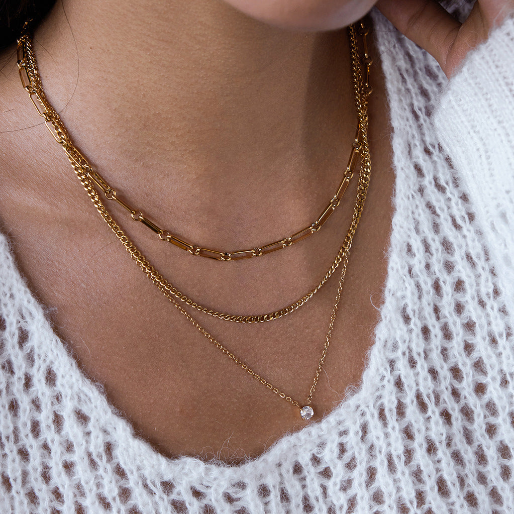 A different angle of a model wearing The Charites Necklace, capturing the brilliant shine of the gold chains and the sparkle of the crystal pendant.
