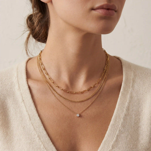 An elegant shot of a model wearing The Charites Necklace, showing how the three gold strands create a full and perfectly spaced necklace stack.