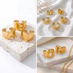 Aesthetic product photography of chunky gold alphabet rings on white stone background.