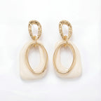 Cream enamel abstract drop earrings with textured gold stainless steel finish.