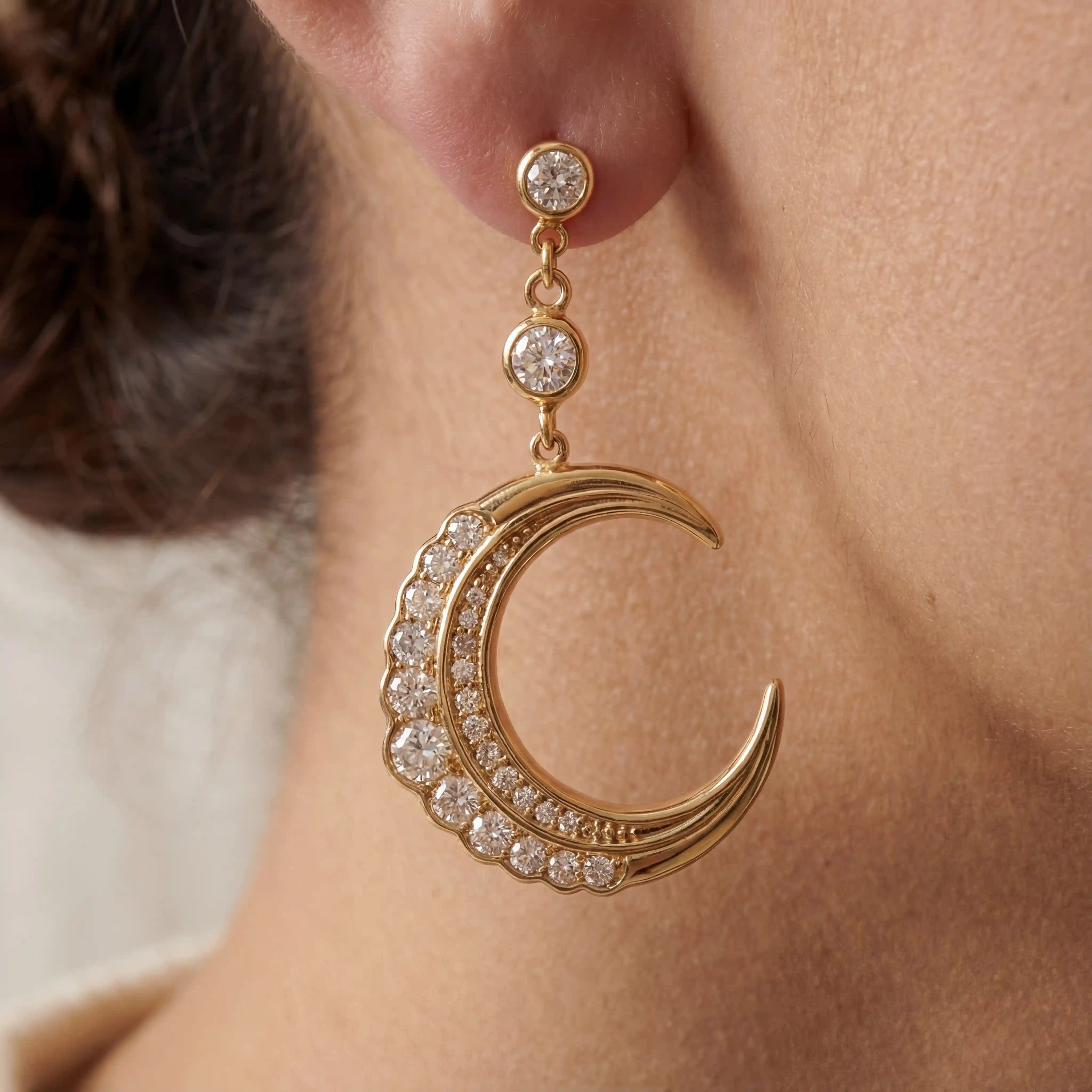 Close up of gold crescent moon earring with pave crystals on model ear celestial jewelry. Main image