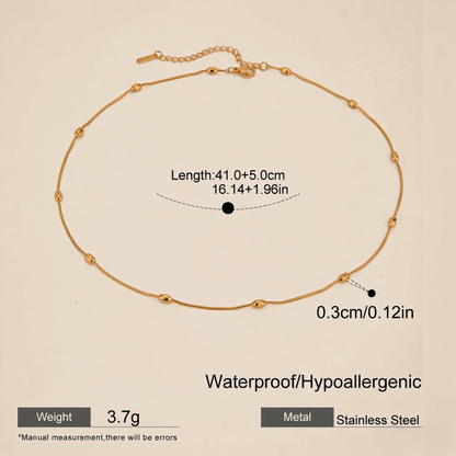 Extreme close-up macro shot of the delicate gold beads on the chain, highlighting texture and craftsmanship.