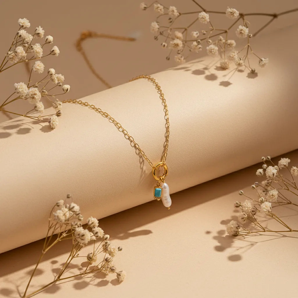 The Astoria Necklace for December, featuring a bright turquoise-blue birthstone that provides a vibrant pop of color against the pearl and gold.