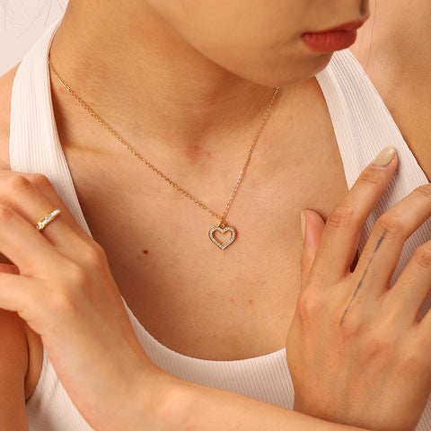 An elegant model with her hand gently on her chest, drawing attention to the delicate beauty and romantic feel of The Devotion Necklace