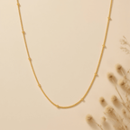 Luminova Dotted Bead Gold Necklace isolated on a white gold background, showcasing the delicate bead detail.