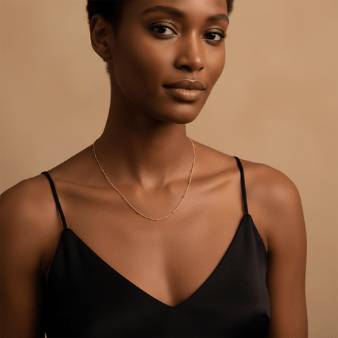 Woman wearing the Dotted Bead Chain Necklace alone as a minimalist choker with a black top.