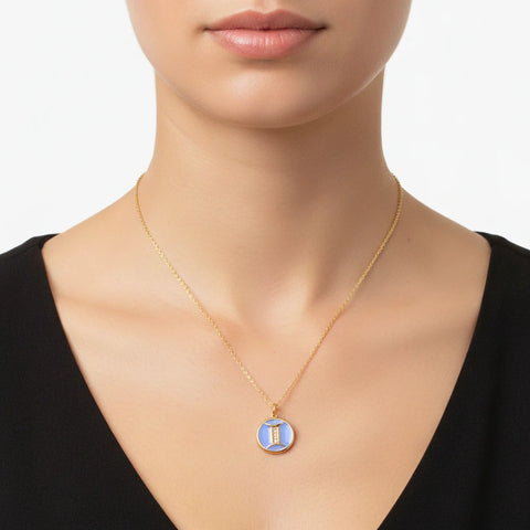 Woman wearing blue enamel zodiac pendant necklace with black outfit everyday style.