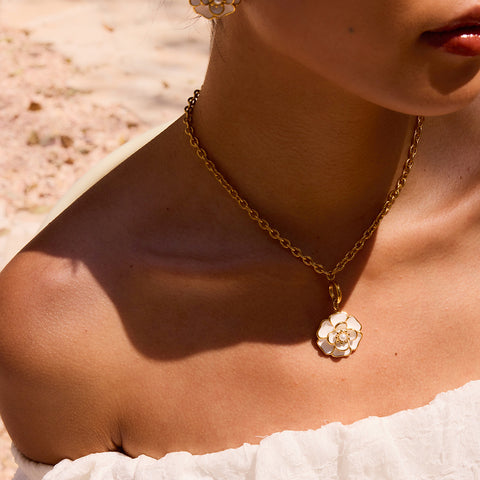 Close-up of a model on the beach, with The Fleur Pendant as the perfect centerpiece for a chic, sophisticated vacation look.