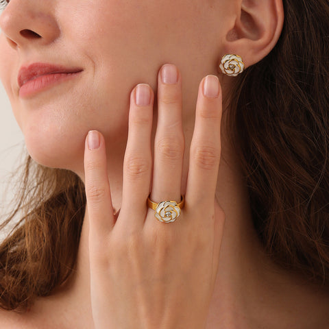 An elegant model with her hand to her face, displaying the complete iconic set, with both The Fleur Ring and the matching Fleur Studs visible.