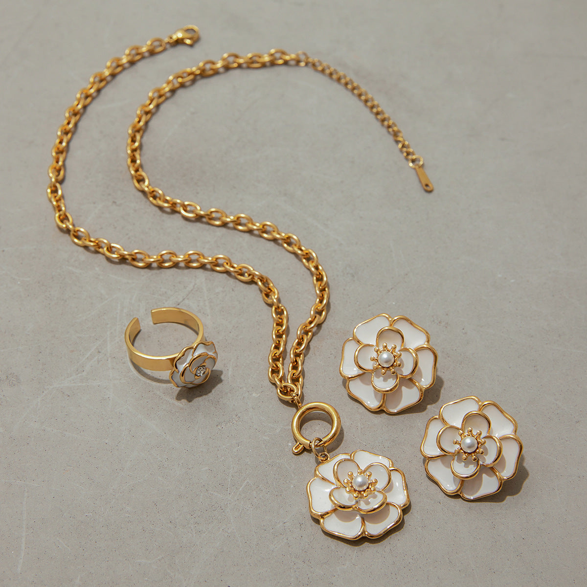 An artistic flat lay of the full Fleur Collection, including the necklace, earrings, and ring, showcasing the complete, iconic Luminova set.