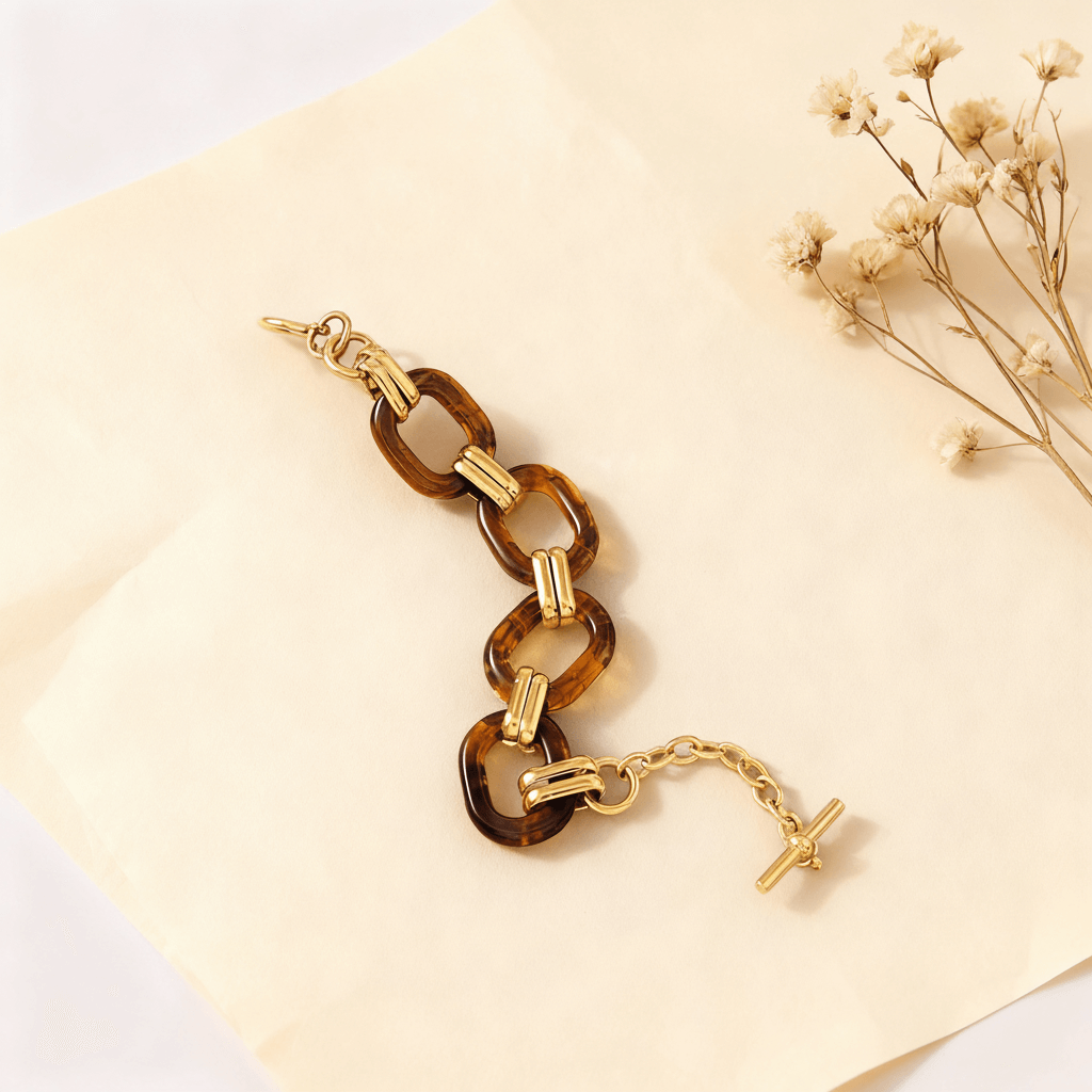 The Florence statement bracelet laid out in a gentle S-curve, showcasing the fluid connection between the chunky resin links and the gold hardware.