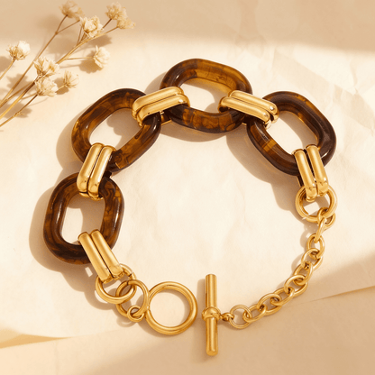 The Florence Link Bracelet by Luminova displayed on a luxurious silk background, showing a detailed view of the warm tortoiseshell resin links and the 18k gold-plated toggle clasp.