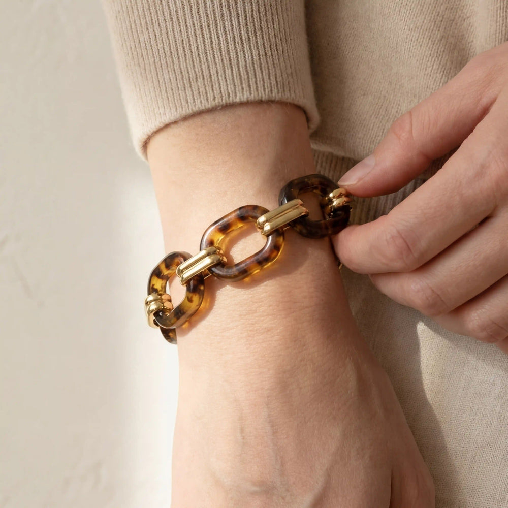 Close up of woman wearing Florence tortoise shell link bracelet with gold accents.