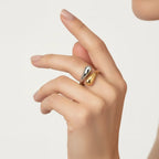  model's hand wearing the two-tone Fluid Pebble Ring, showcasing how the unique gold and silver design wraps elegantly around the finger.