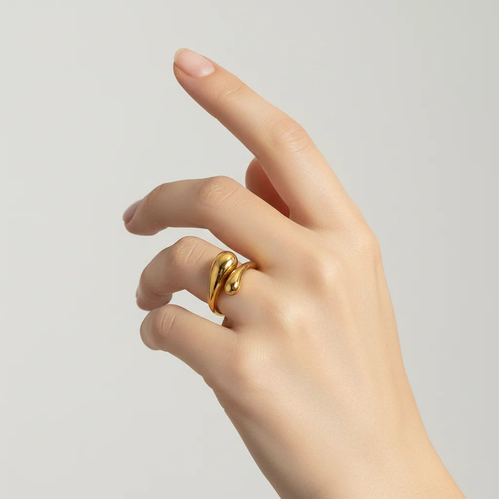 Close-up of a woman's hand wearing the all-gold Fluid Pebble Ring, demonstrating its bold yet minimalist statement quality.