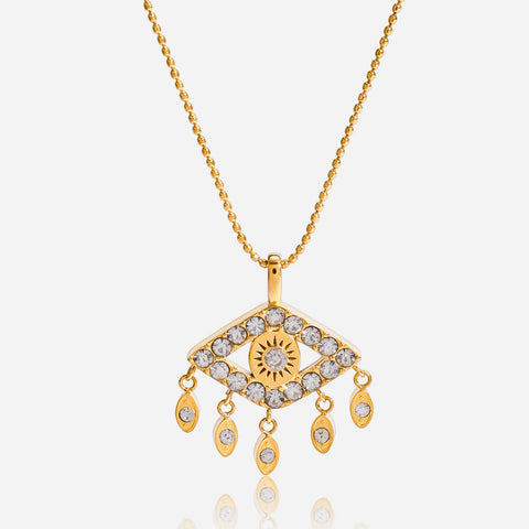 A detailed studio shot of The Fortuna Necklace by Luminova, showcasing the delicate, sparkling crystal evil eye pendant with its dangling tassels and its reflection.