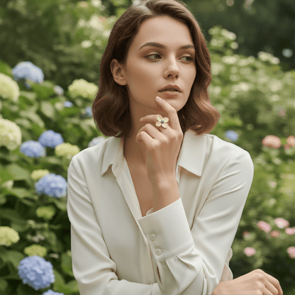 A close-up of a model wearing the Gaia Ring during the golden hour. The warm, low sun highlights the rich texture of the hammered gold petals, making the entire ring glow with an earthy, divine light.