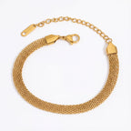 Gold mesh bracelet flat woven stainless steel chain on white background.