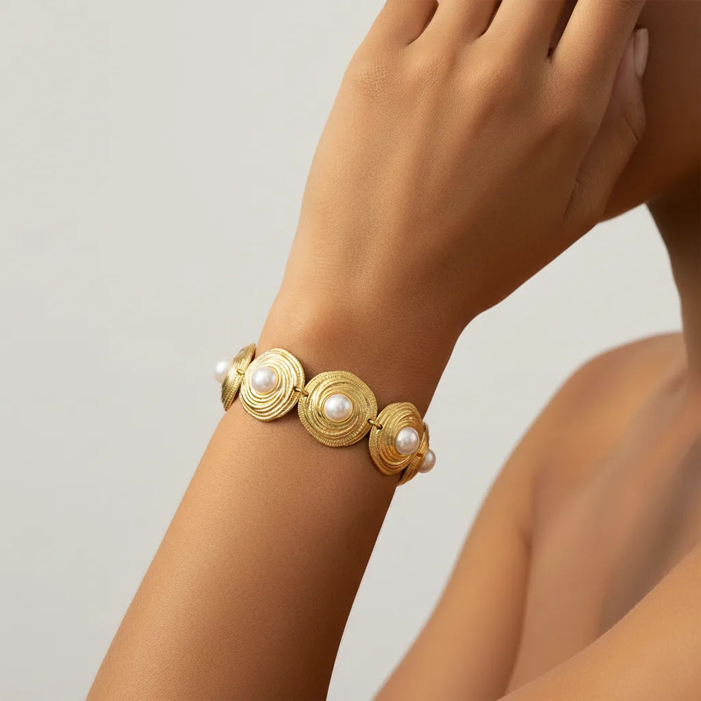 Detailed shot of The Hera Bracelet on a model's arm, demonstrating how the gold medallions articulate and wrap comfortably around the wrist.